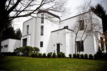 white Bauhaus house exterior with green yard and trees