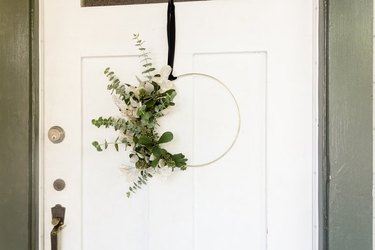 wreath with eucalyptus and gold hoop hanging from front door