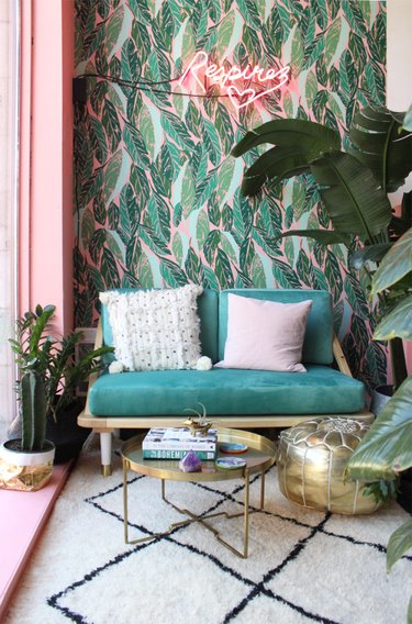 tropical living room with neon sign and palm leaf wallpaper