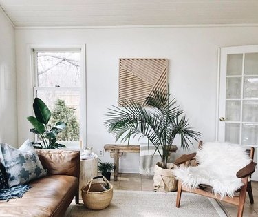 tropical living room with leather sofa and sheepskin fun on lounge chair