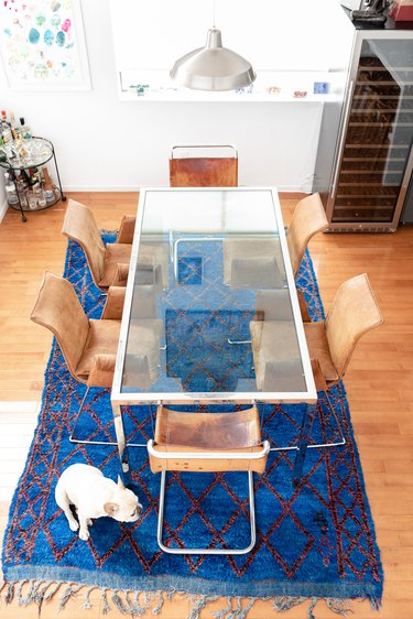 Glass dining room table with blue rug