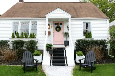 home exterior house color for 2021 in white with pink door and black striped steps