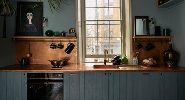 blue kitchen with copper backsplash