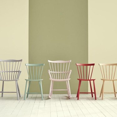row of chairs in different colors with striped wall in the background