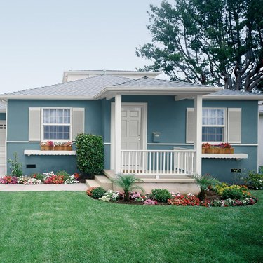 home exterior house color for 2021 in teal with flower boxes and flowers in front yard