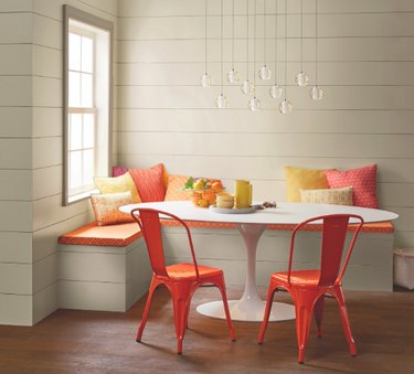 dining room space with banquette and orange chairs