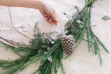 Attaching pinecone to wreath