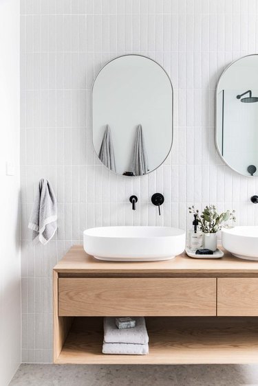 white bathroom with floating vanity and black wall mount fixtures