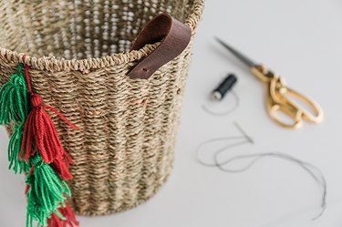 Sew leather handles onto the sides of the basket.