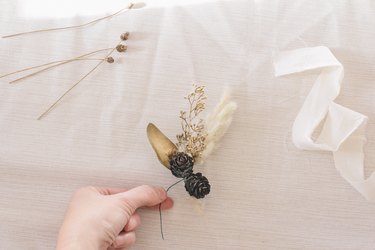 Tying pinecones to floral stems