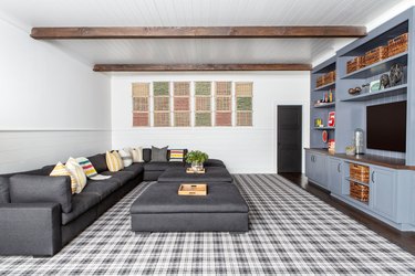 farmhouse family room idea with plaid rug and wood beams