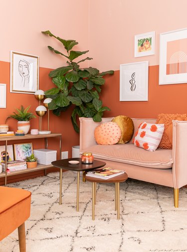 warm colors in living room with orange and pink walls and neutral rug