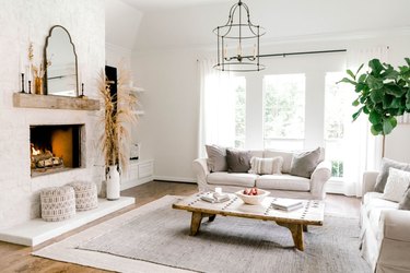 white farmhouse family room idea with fireplace and white furniture