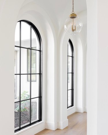 white hallway with black paned arched windows