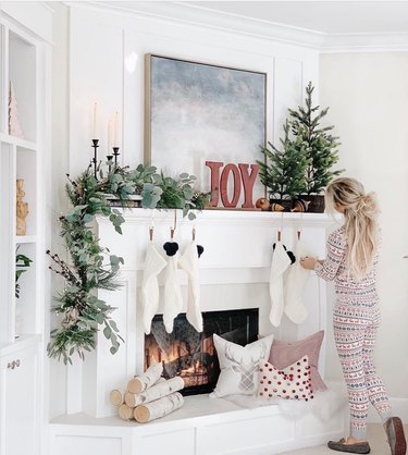 Simple gold Christmas stocking holder with white mantel and garland