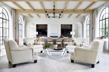 white living room with arched windows and wooden beams on ceiling