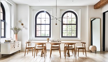 white dining room with arched windows and dining table