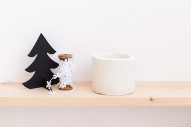 concrete candle sitting on wooden shelf