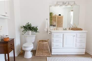 White bathroom with basket and white console sink