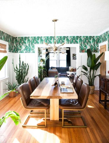 tropical dining room wall idea with patterned wallpaper in bohemian space with wood table