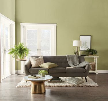 living room with dark couch and green walls