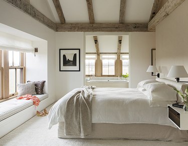 minimalist farmhouse bedroom with window seat and ceiling beams