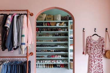 Pink and turquoise walk-in closet with extensive shoe shelving.