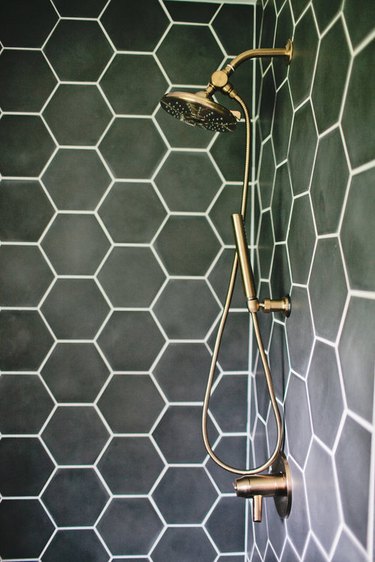 hexagonal green bathroom tile idea in the shower with brass fittings