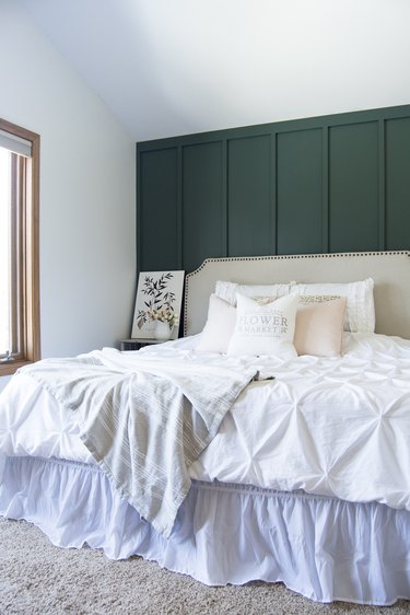 farmhouse bedroom with dark green board and batten accent wall