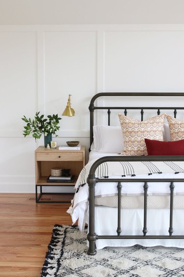 farmhouse bedroom with metal bed frame and patterned rug