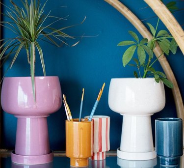 vases in different colors near a blue wall 