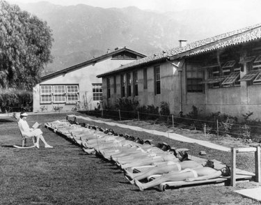 row of sunbathing young boys in California