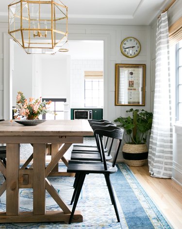 dining room rug idea with darker pattern in navy blue beneath rustic wood table