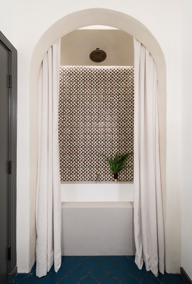 white bathroom color with patterned backsplash, arch and navy blue floors