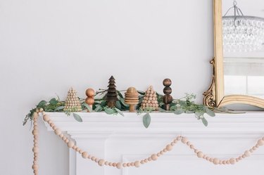 mini wooden holiday scene set on a mantel