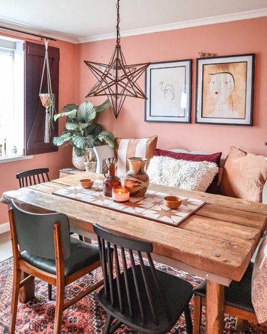 dining room lighting idea with star-shaped pendant in bohemian space with pink walls