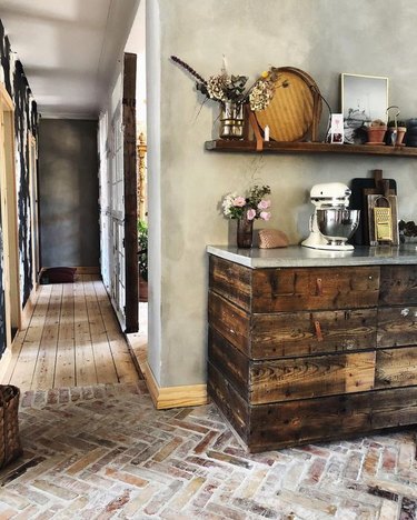 rustic kitchen with herringbone pattern flooring and wood cabinets