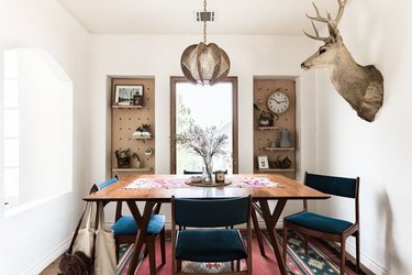 dining room area with animal head and pegboard storage