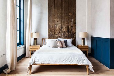 cream industrial color palette in bedroom with wood paneling and bed in the middle