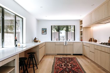 oak cabinets in modern kitchen with colorful runner