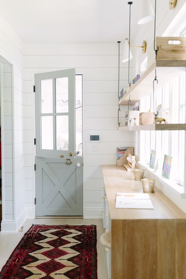 shelving with tchotchkes and Dutch style door with shiplap walls