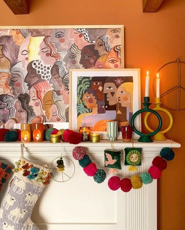 boho Christmas theme decor idea with stockings and garland hanging from mantel