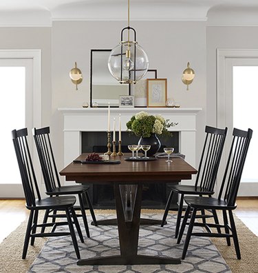 dining room lighting idea with pendant over table and wall sconces at fireplac e
