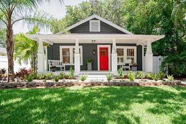 craftsman house with white eaves and a red door