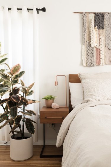 bedroom with plant and wall hanging