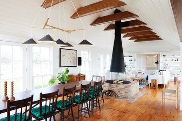 white living room with freestanding coastal fireplace and wooden beams on the ceiling