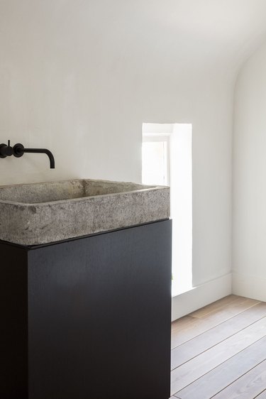 textured concrete bathroom sink on black pedestal