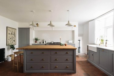 gray cabinets in kitchen with saltillo tile flooring