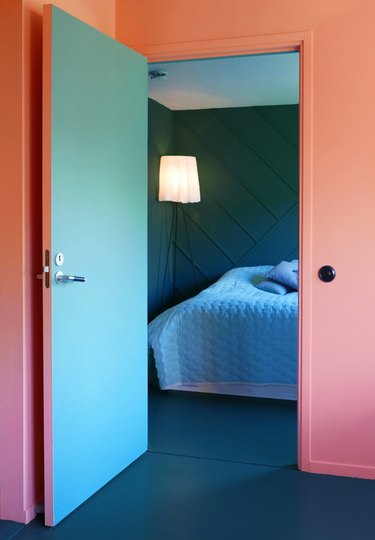 coral walls with teal door opening onto teal bedroom