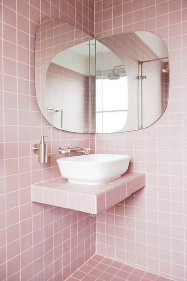 modern bathroom with pink tiles on walls, floor and countertops